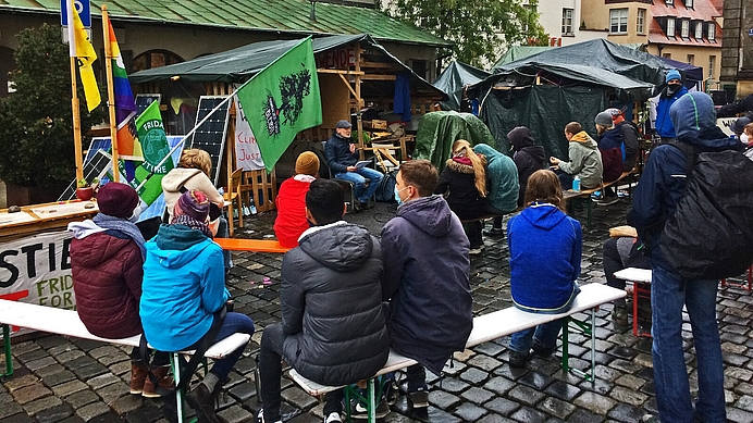 Aktivisten bei politischer Versammlung im Klimacamp Augsburg